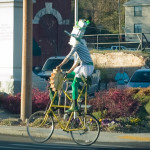 A jovial cyclist enjoys riding in the St. Patrick's Day parade.
