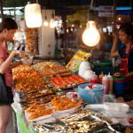 Many different kind of fish for sale. The girl in th red apron selling them is also wondering why anyone would ever buy them...just look at her face.