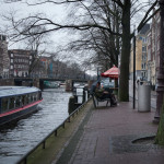 A couple sits and acts romantic outside of the Anne Frank House. They briefly thought of history, imagined what it would be like if they were capable of profound feelings, then resumed taking the standard photos to show their friends back home.